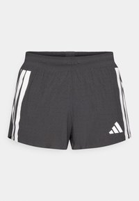 Shorts de sport gris foncé en tissu respirant, avec des bandes blanches sur les côtés et un logo. Le design comprend une texture perforée pour la ventilation.