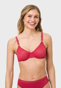 Red fabric bra with smooth cups and adjustable straps, featuring a minimal design and light seam accents. Pairing with a matching brief.