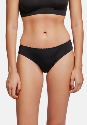 Bikini de algodón negro con mezcla de tejidos, con una cintura de corte bajo, bordes de cinturilla con forma de ondas y un diseño minimalista. Textura suave.