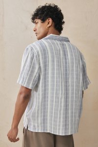 Casual short-sleeve shirt in lightweight fabric, featuring vertical blue and white stripes, a relaxed fit, and a classic collar.