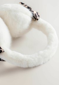 Baltai kailiniai ausų apvalkalai su tekstūruota, minkšta apdaila ir juodai-beige leopardų rašto juostele vienoje pusėje. Apvalios formos, užtikrinančios ausų dengimą.
