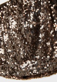 Paillettenstoff in Dunkelbraun, mit glänzenden, quadratischen Pailletten in Roségold und Silber, die dicht die Oberfläche bedecken und eine strukturierte Erscheinung verleihen.