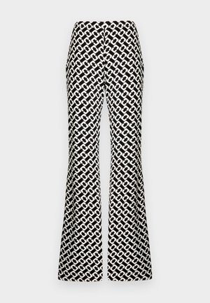 Pantaloni evazați alb-negru cu un model geometric, având o textură netedă și o talie înaltă, care se extind până la podea.