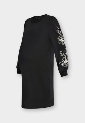 Fekete, hosszú ujjú, térdig érő ruha fehér virágos hímzéssel az ujjakon és bordázott mandzsettákkal.
