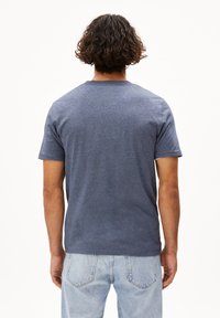 Maglietta a maniche corte blu realizzata in morbido tessuto misto cotone. Presenta un collo giro e una vestibilità rilassata con una superficie testurizzata.