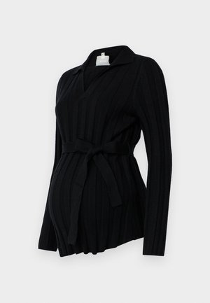 Zwarte geribbelde zwangerschapsblouse met een kraag, lange mouwen en een strikceintuur in de taille. Zachte breiwerk textuur met een relaxte pasvorm.