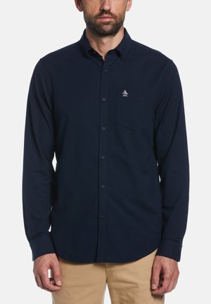Navy long-sleeve button-up shirt made of smooth fabric features a patch pocket and a small embroidered logo on the upper left side.