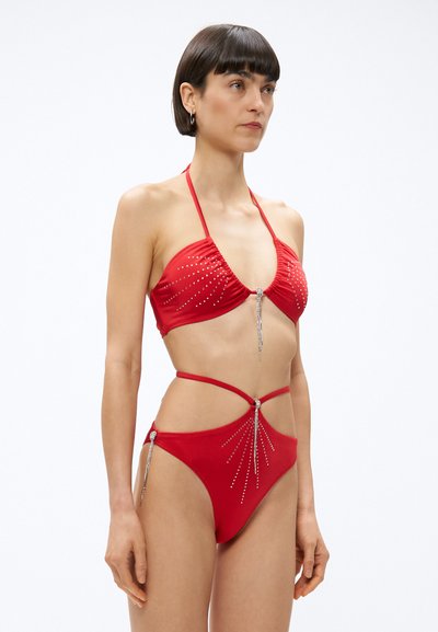 Rotes Bikini mit Strassverzierungen. Neckholder-Oberteil mit gerafftem Stoff, tief sitzender Slip mit Riemendetails und dekorativen Akzenten.