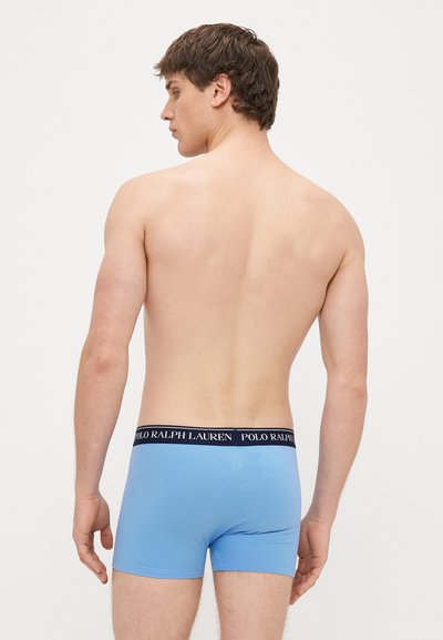Μπλε βαμβακερά μποξεράκια με μαύρη ζώνη μέσης που φέρει το κείμενο "POLO RALPH LAUREN." Ο σχεδιασμός περιλαμβάνει εφαρμοστή κοπή και λεία υφή.