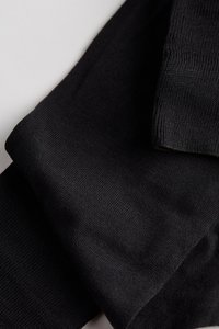 Sorte bomulds leggings med en glat tekstur, der har en tætsiddende pasform og elastisk talje. Stoffet ser let og strækbart ud.