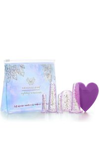 Zestaw Crystal Love zawiera trzy przezroczyste kubki z złotym brokatem oraz silikonową podkładkę w kształcie serca w kolorze fioletowym, wszystko zapakowane w przezroczystą torbę na zamek.