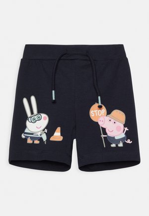 Marineblå shorts med tegnet kanin iført briller, der holder et værktøj ved en trafikkegle, og en gris i hjelm, der holder et stopskilt.