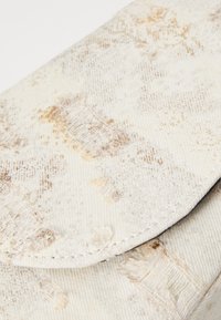 Hvit teksturert stoffkveldsveske med subtile beige mønstre, med klafflås og sydd kanter. Holdbart materiale.
