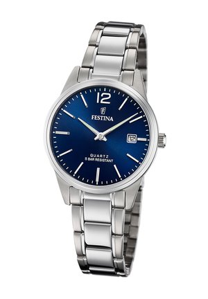 Montre en acier inoxydable argenté avec un cadran bleu rond, des index horaires blancs et un affichage de la date. Elle est dotée d'un bracelet à maillons résistant et d'un mouvement à quartz.