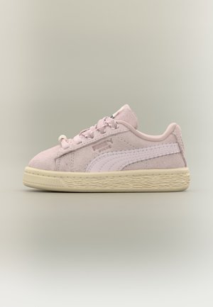 Baskets Puma en daim rose clair avec bande blanche sur le côté, lacets roses et semelle beige texturée sur fond neutre.