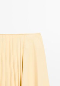 Off-the-shoulder jurk met een geplisseerd ontwerp in zachte gele stof. Soepele textuur, gestructureerde silhouette en minimale details.