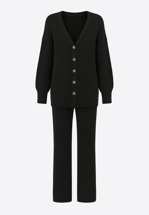 Sort ribstrikket cardigan med dyb V-hals og seks knapper foran, kombineret med matchende ribstrikkede bukser. Blød tekstur og afslappet pasform.
