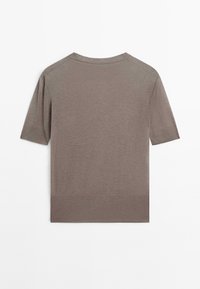 Khaki sweter z krótkim rękawem, wykonany z dzianiny, z okrągłym dekoltem, prążkowanym brzegiem i gładką fakturą. Bez wzorów ani widocznych akcentów.