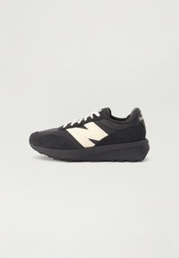 Fekete sneaker, bársony és hálós felsőrésszel, fehér logóval, texturált talppal és fűzőzárral. Lekerekített orrész és párnázott kialakítás.