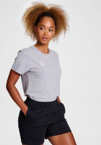 Gray cotton t-shirt with short sleeves and a round neck. Features a small white logo. Paired with black elastic waistband shorts.