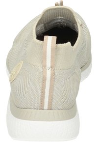 Baskets slip-on beige clair avec une tige en maille texturée, semelle blanche et un accent en tissu rayé à l'arrière.