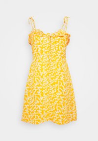 Keltainen kukallinen mekko, jossa on röyhelökaul US ja säädettävät olkaimet, sekä istuva yläosa. Kuvio sisältää pieniä valkoisia kukkia ympäriinsä.