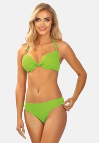 Zielony zestaw bikini składający się z wiązanego topu braletki z regulowanymi ramiączkami oraz pasujących majtek z wysokim stanem, wykonany z gładkiego, elastycznego materiału.