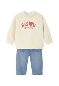 Helles beiges Sweatshirt mit "BISOU D'AMOUR" in Rot, gerippter Rundhalsausschnitt, kombiniert mit blauen Jeansshorts mit Gesäßtaschen.