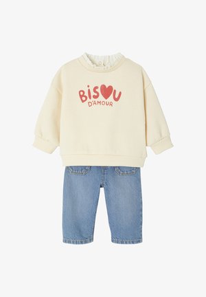 Helles beiges Sweatshirt mit "BISOU D'AMOUR" in Rot, gerippter Rundhalsausschnitt, kombiniert mit blauen Jeansshorts mit Gesäßtaschen.