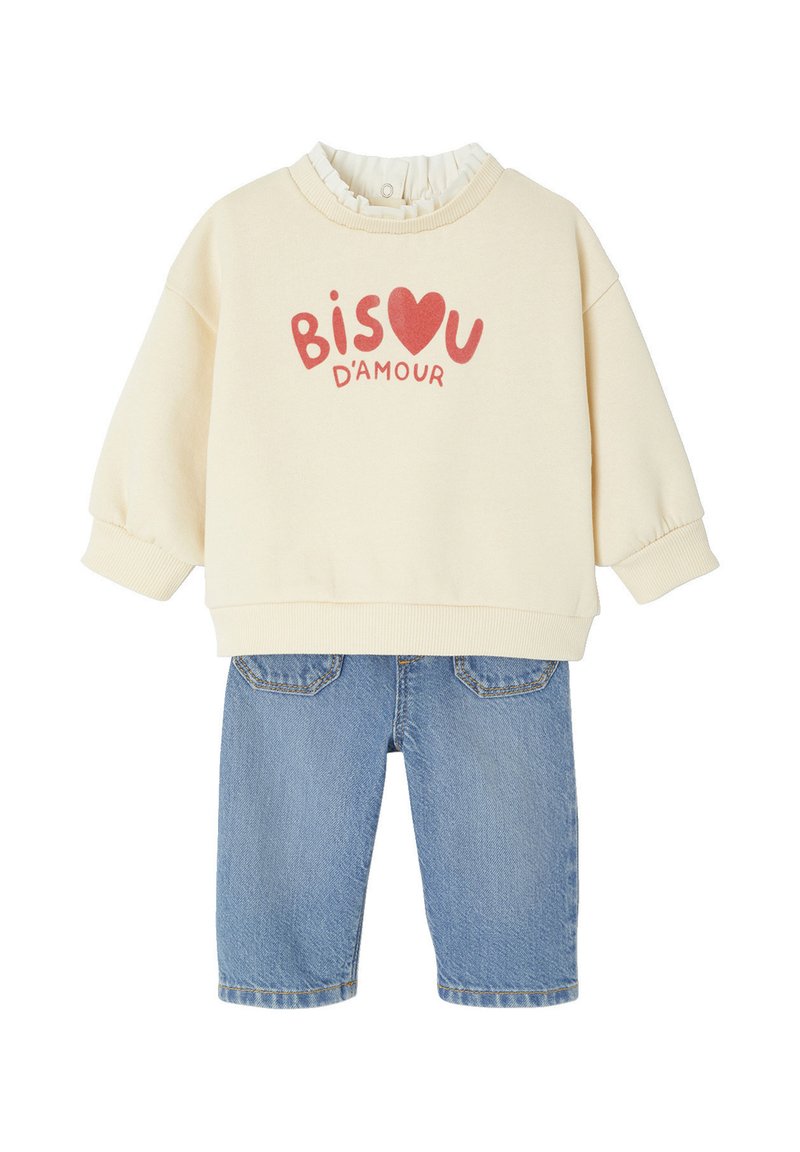 Helles beiges Sweatshirt mit "BISOU D'AMOUR" in Rot, gerippter Rundhalsausschnitt, kombiniert mit blauen Jeansshorts mit Gesäßtaschen.