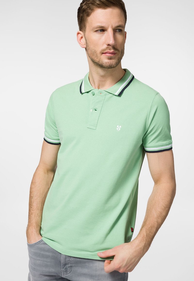 Miętowa koszulka polo z mieszanki bawełny, z kontrastowym czarno-białym kołnierzykiem i mankietami oraz małym logo na piersi.