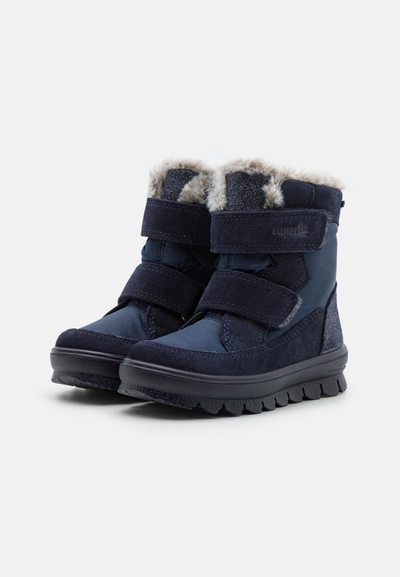 Marineblaue Winterstiefel mit doppelten Klettverschlüssen, Kunstfellfutter oben und strukturierten Gummisohlen für Grip und Langlebigkeit.