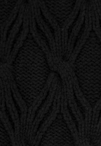 Černá pletená látka s texturovaným diamantovým vzorem se zvýrazněnými diagonálními liniemi, zobrazující silné příze pro útulný vzhled.