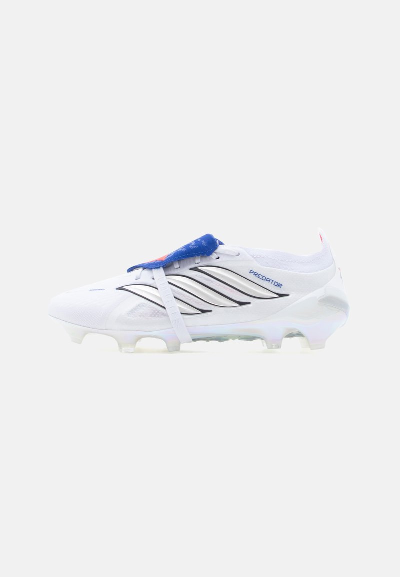 Scarpa da calcio Adidas Predator bianca con strisce nere, linguetta blu e tacchetti modellati sulla suola per trazione su campi in erba.