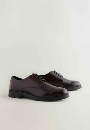 Burgundy leather dress shoes with a smooth finish, rounded toe, and black rubber sole. Features lace-up closure and minimal stitching detail.