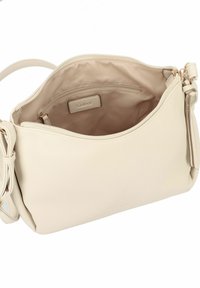 Bolso cruzado de piel beige con superficie texturizada, cierre de cremallera y una sola correa para el hombro. El interior incluye un bolsillo y etiqueta de la marca.
