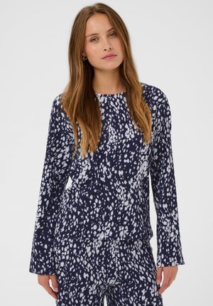 Langärmliges Oberteil aus weichem Stoff, mit marineblauem Hintergrund und weißen Sprenkeln. Rundhalsausschnitt und lockere Passform.