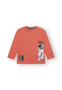 Camisa de manga larga de color coral hecha de tela suave, con estampados gráficos en negro y texto en la parte frontal, con cuello redondo y corte relajado.