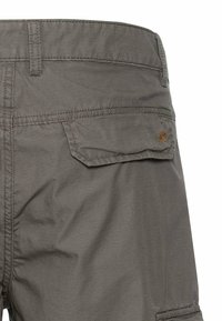 Grå cargo shorts med et struktureret mønster, fem lommer og et logo patch. Stoffet ser let og slidst�ærkt ud.