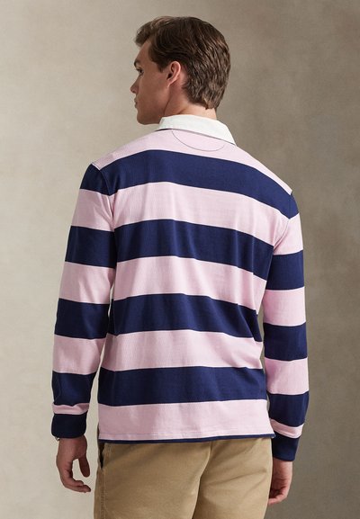 Pikad varrukadega polo-särk, millel on horisontaalsed triibud tumesinisel ja heledal roosal, klassikalise valge kraega ja tekstuurse kudumiga kangas.