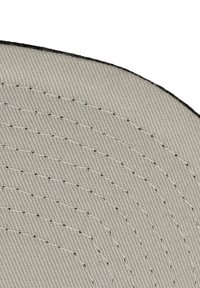 Tissu gris avec une surface texturée, présentant de subtils motifs de couture circulaires et un bord noir.