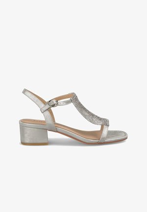 Silver ankle-strap sandal with a block heel, featuring a shimmering rhinestone embellishment along the strap and a smooth leather-like texture.