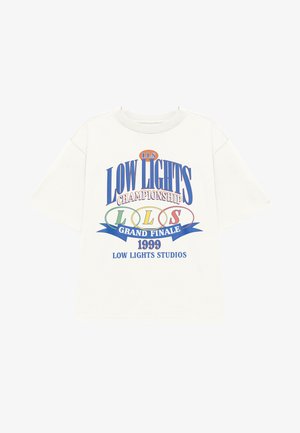 T-shirt en coton écru avec des manches courtes, présentant des textes et graphiques multicolores : « CHAMPIONNAT DES FAIBLES LUMIÈRES » et « 1999 ».