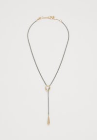 Collier en chaîne argentée avec un pendentif en forme de goutte d'eau doré suspendu à une boucle dorée sur fond blanc.