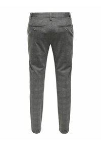 Pantalon pour homme gris sur mesure avec passants pour ceinture, deux poches arrière passepoilées fermées par des boutons et une coupe ajustée, vu de dos.