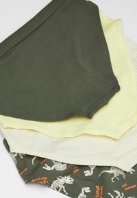 Trois paires de sous-vêtements pour enfants : vert olive, jaune clair et crème rayé, avec des motifs de dinosaures et du texte sur la paire inférieure.
