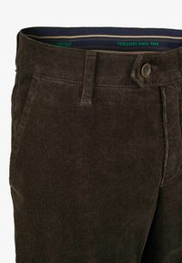 Braune Cordhosen mit strukturierter Oberfläche, mit einem Knopfverschluss vorne und Seitentaschen. Futterbund mit grünen Streifen.