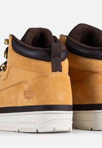 Sneaker alte in suede beige presentano dettagli in pelle marrone, occhielli dorati, un colletto in maglia testurizzata e suola in gomma nera.