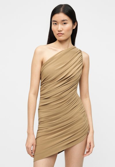 Μίνι φόρεμα με έναν ώμο, ρυτιδωτό, σε μπεζ ύφασμα. Διαθέτει draped υφή και ασύμμετρο τελείωμα. Λείο, ελαστικό υλικό για άνεση.