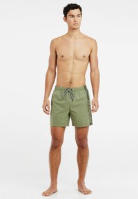 Groene zwembroek met een trekkoord in de taille, met een zijlogo en een eenvoudige uitstraling. Gemaakt van lichtgewicht, sneldrogend materiaal.